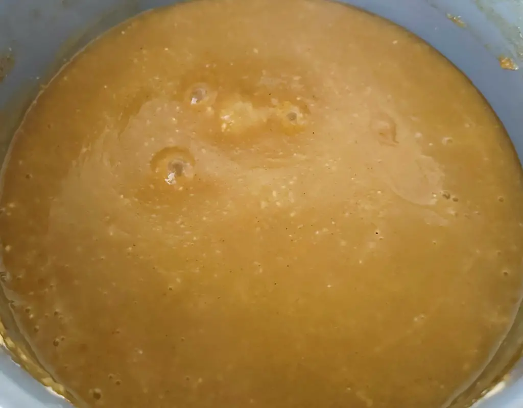 A pot of simmering homemade vegan gravy showing desired thickness