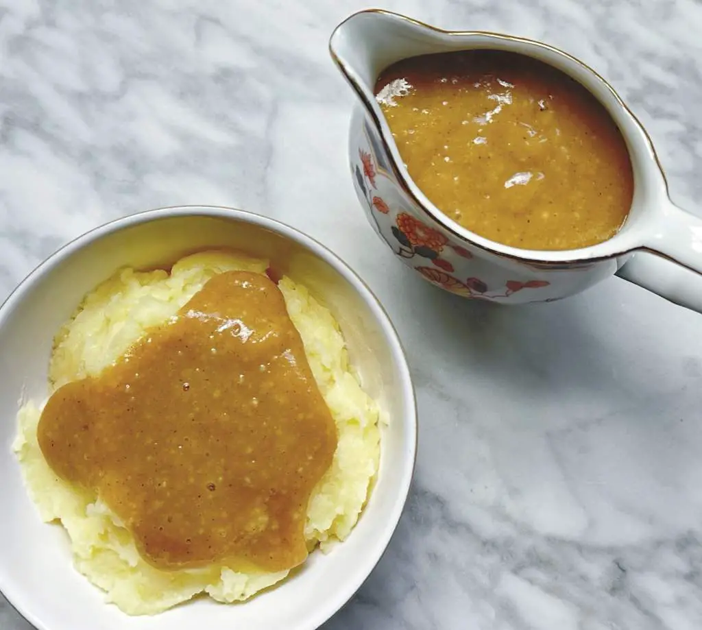 Finished easy homemade vegan gravy in boat and poured over mashed potatoes in a small bowl
