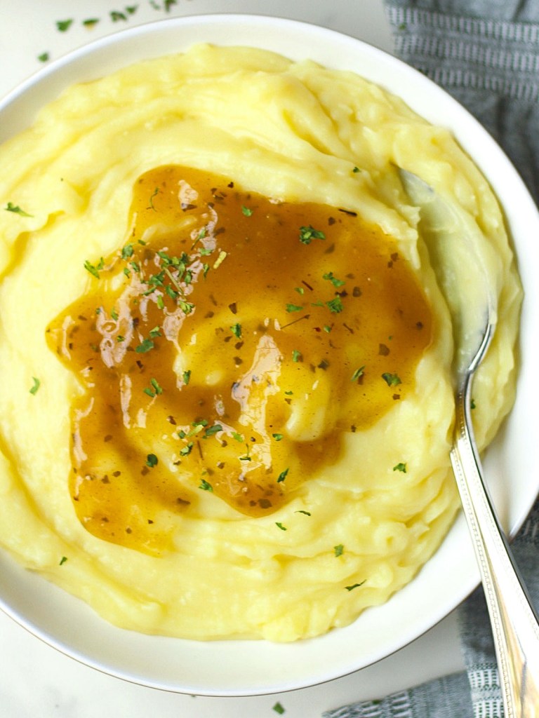 bowl of mashed potatoes with vegan gravy on top