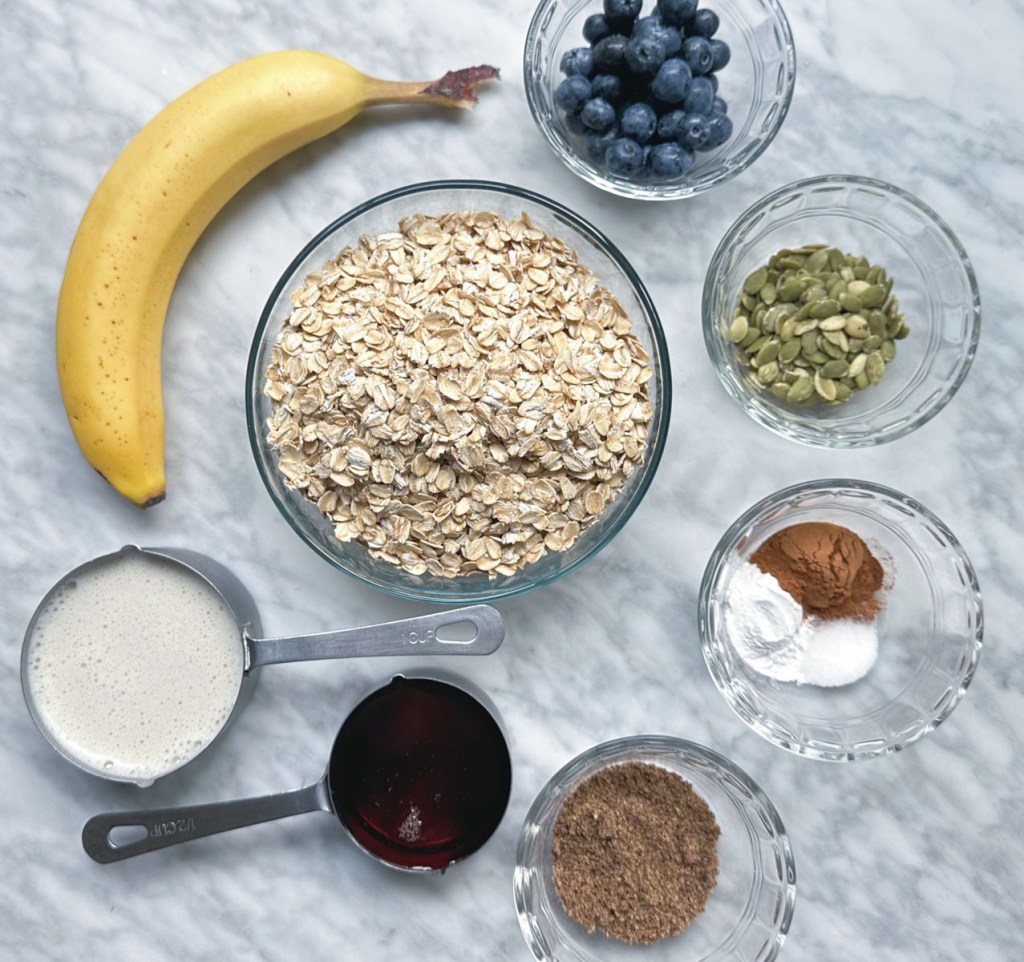 ingredients for blueberry banana baked oatmeal on a white marble surface
