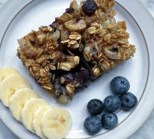 Baked oatmeal on a plate with sliced bananas and blueberries