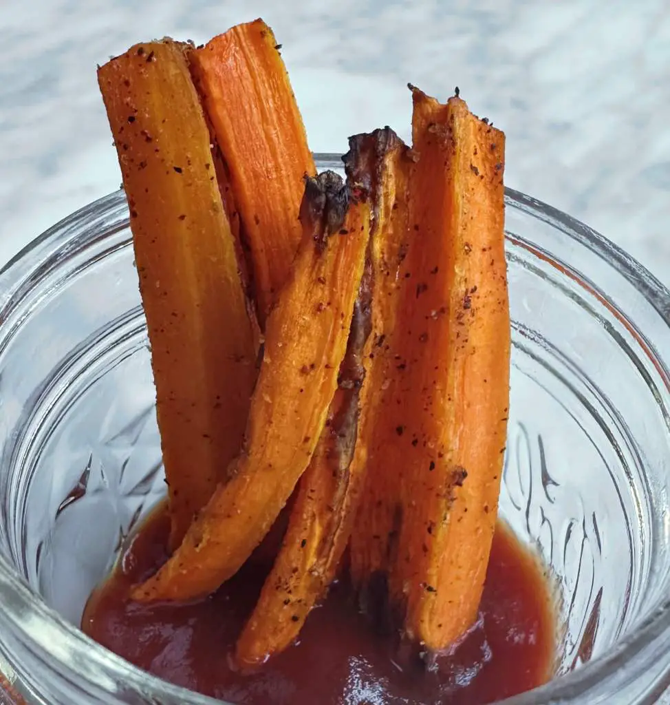 Carrot fries served in small glass bowl with ketchup