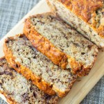 loaf of banana bread on cutting board with 3 slices spread away