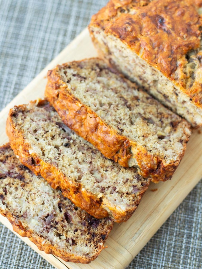 loaf of banana bread on cutting board with 3 slices spread away