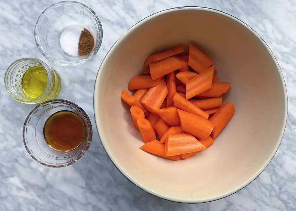 Bowl of chopped carrots showing correct size next to small bowls of ingredients