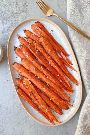 finished maple roasted carrots on a white plate