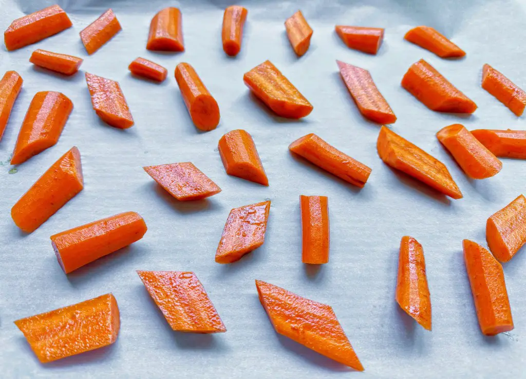 Close up of carrots on a baking sheet prepped for oven