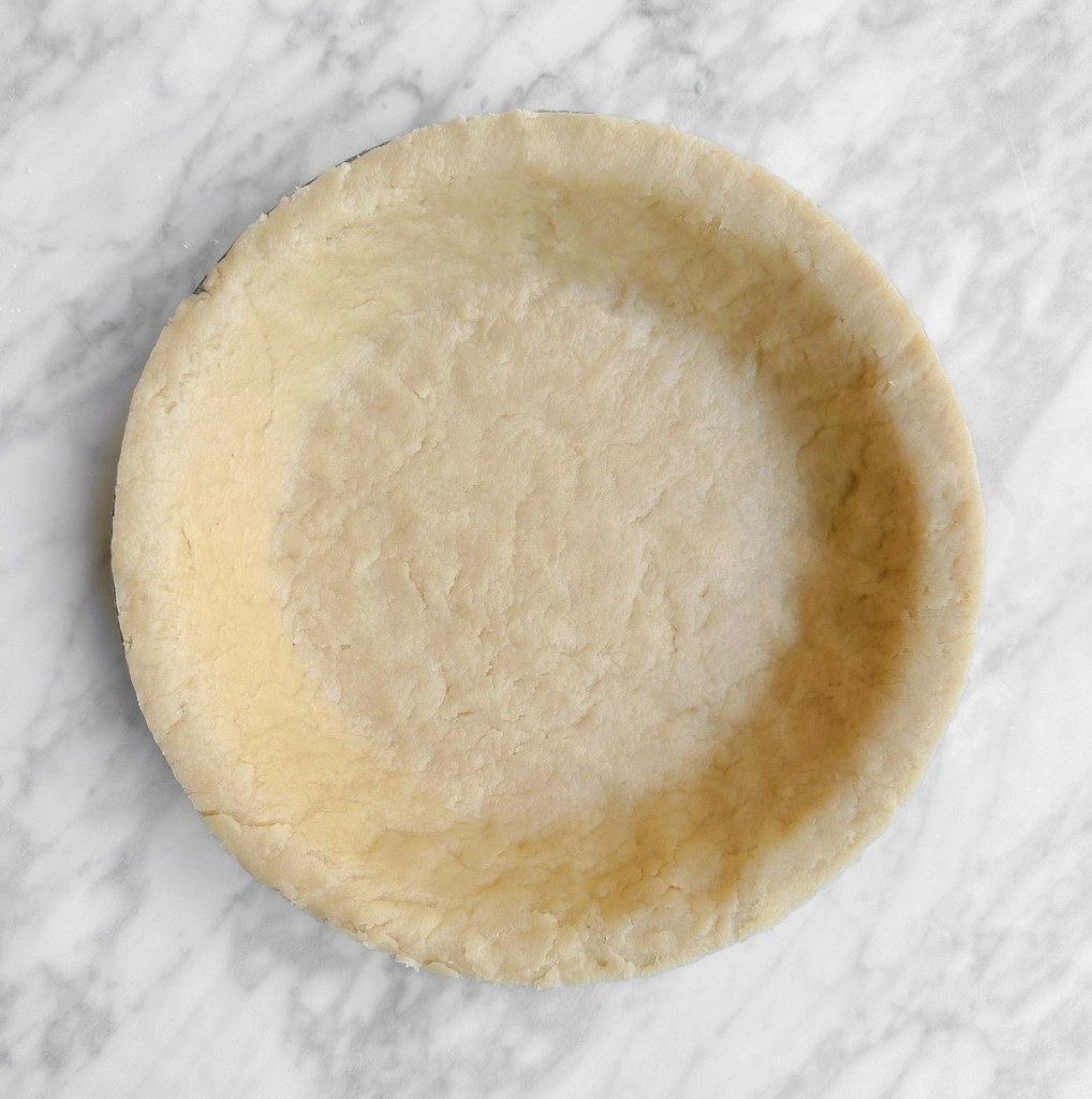 Completed easy vegan pie crust in a pie tin, uncooked.