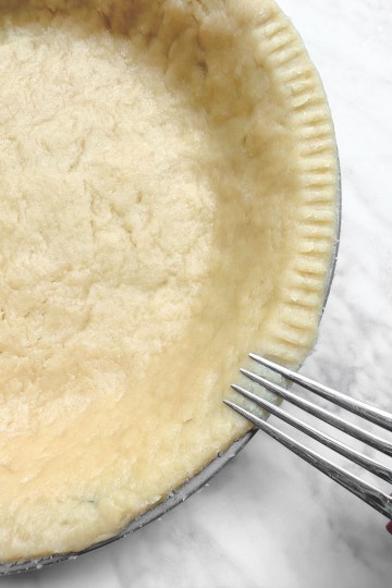 easy vegan Pie crust in tin with fork making marks around edge