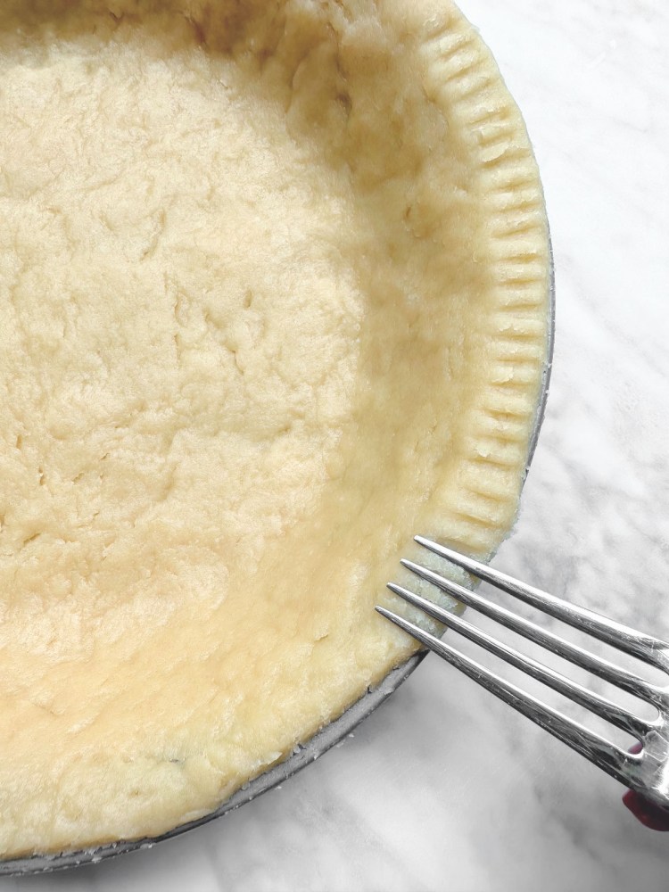 easy vegan Pie crust in tin with fork making marks around edge