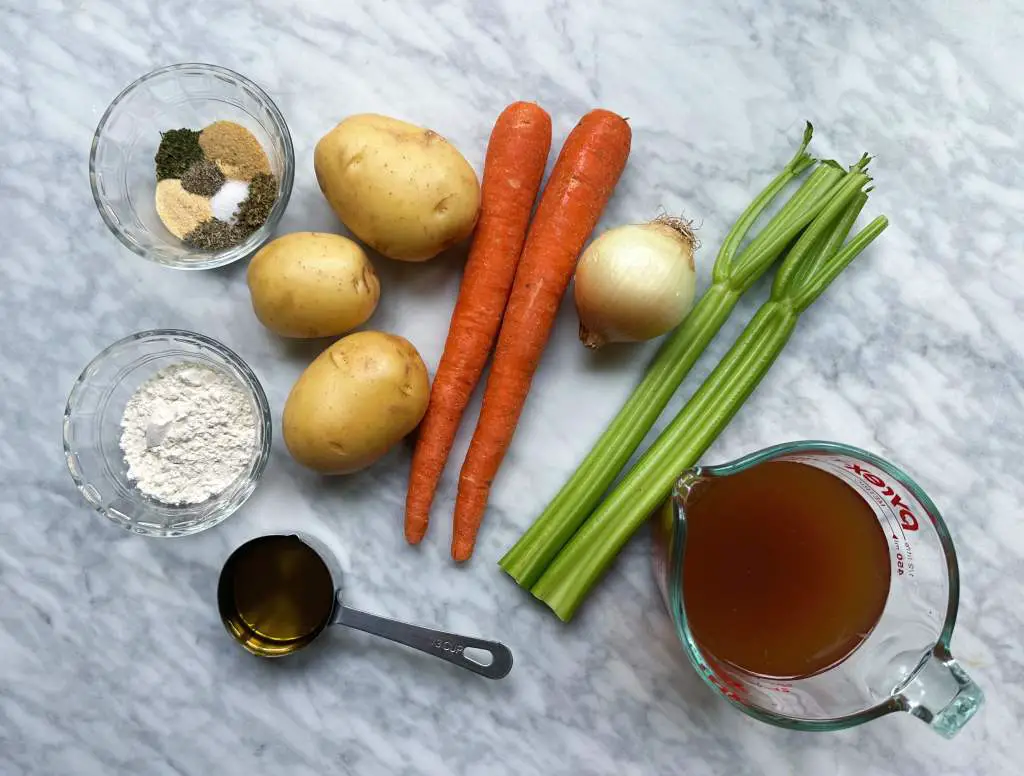All ingredients for vegetable pot pie on white marble background
