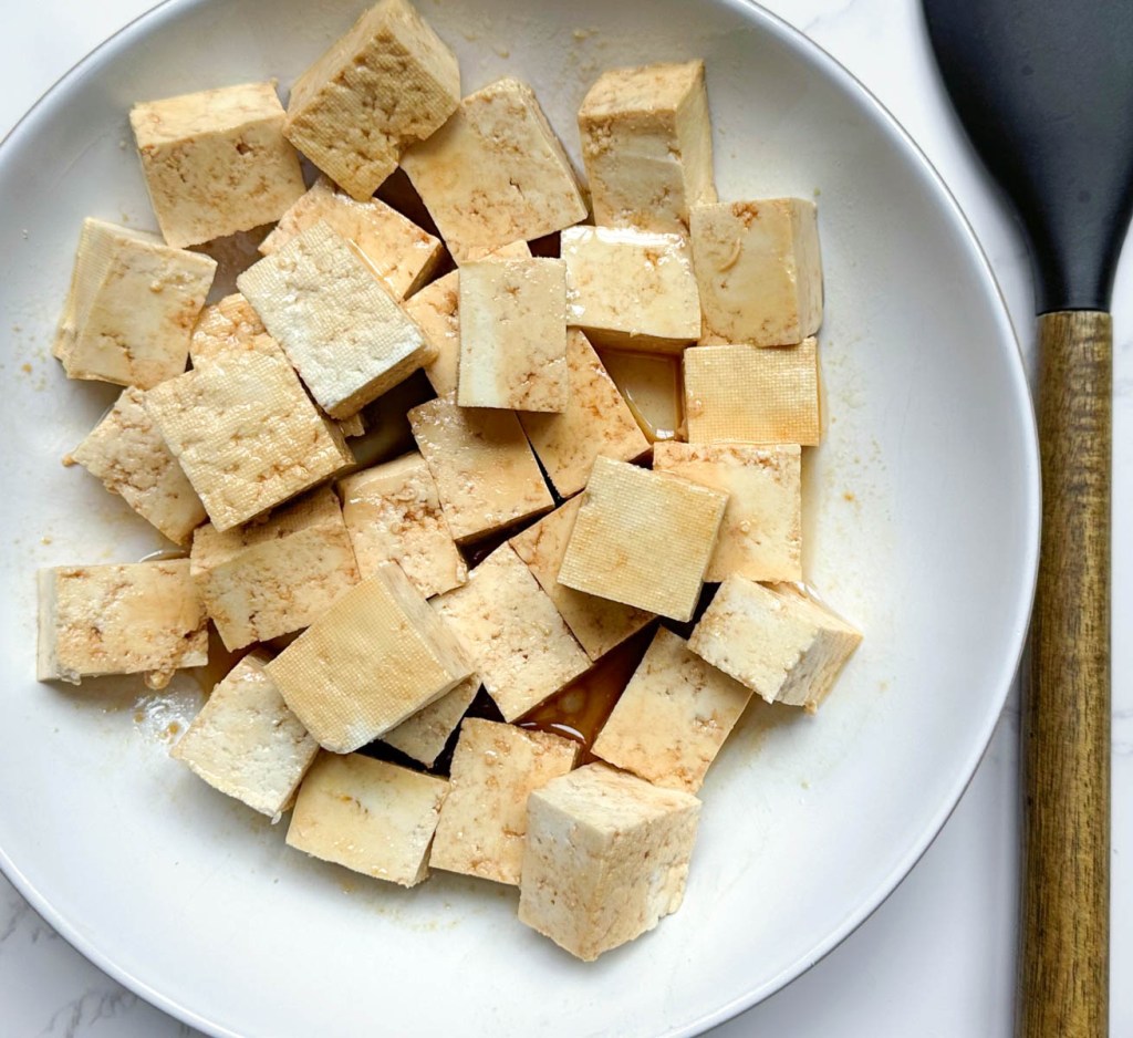 crispy sesame tofu before cooking. Raw tofu coated in oil and soy sauce.