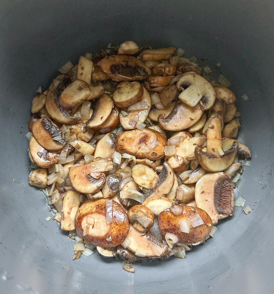 shallot, mushroom and garlic in the instant pot being sauteed