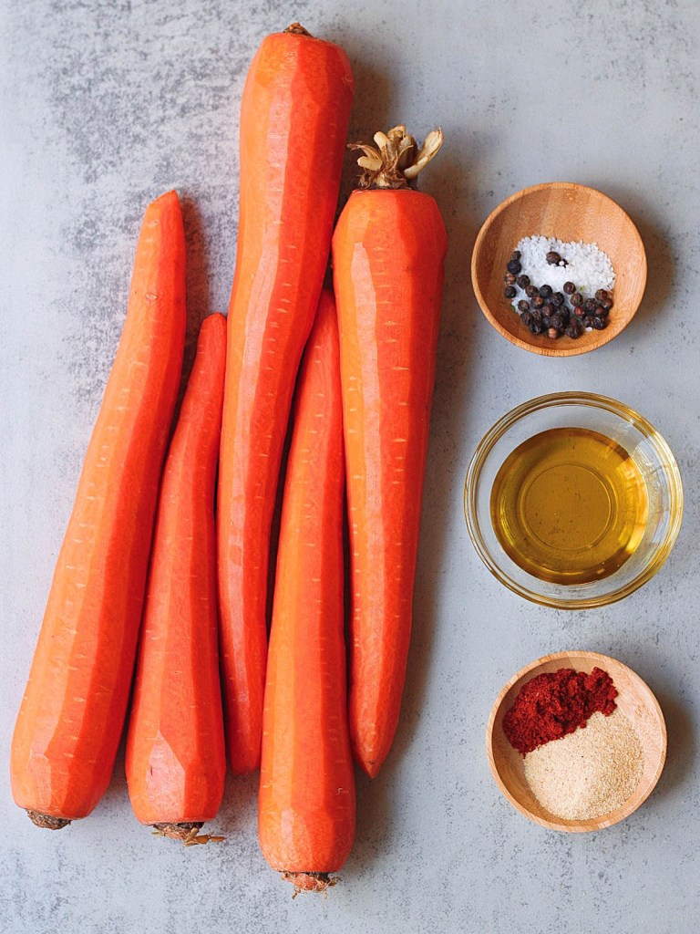 Carrots, spices and olive oil on a white marble background