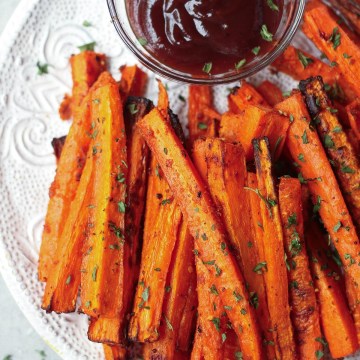 vegan carrot fries on white plate with ketchup