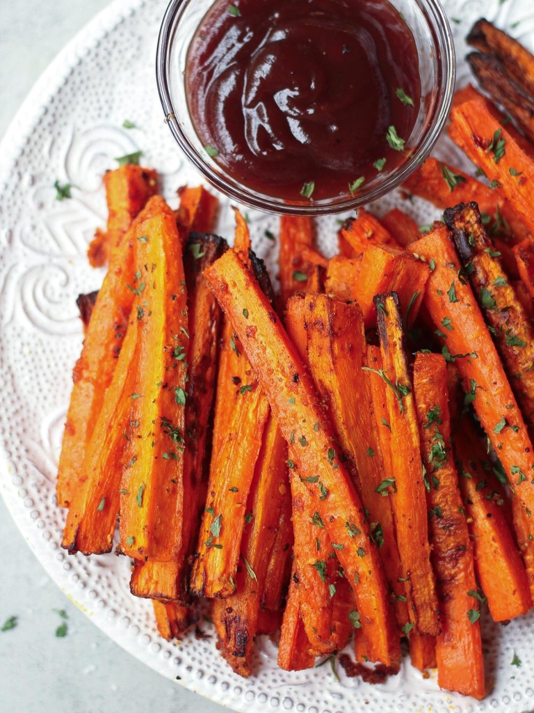 vegan carrot fries on white plate with ketchup
