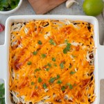 top view finished vegan mexican casserole garnished with enchilada sauce and herbs