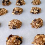 Uncooked vegan oatmeal raisin cookies on cookie sheet