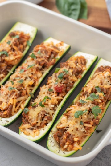 close up finished stuffed zucchini in a baking dish