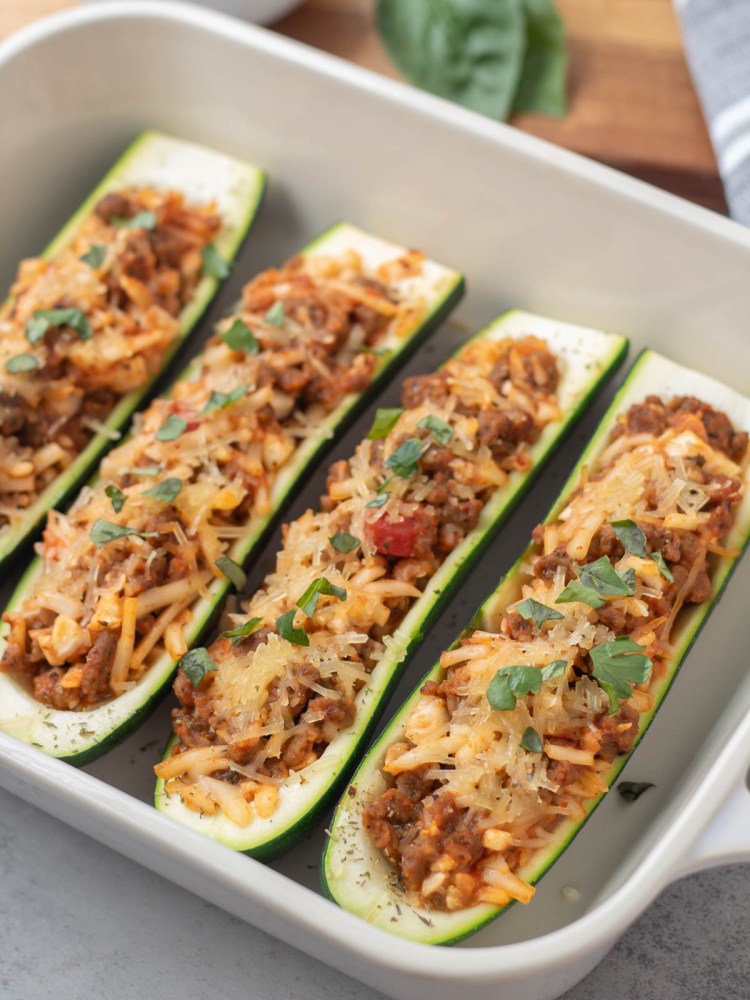 close up finished stuffed zucchini in a baking dish