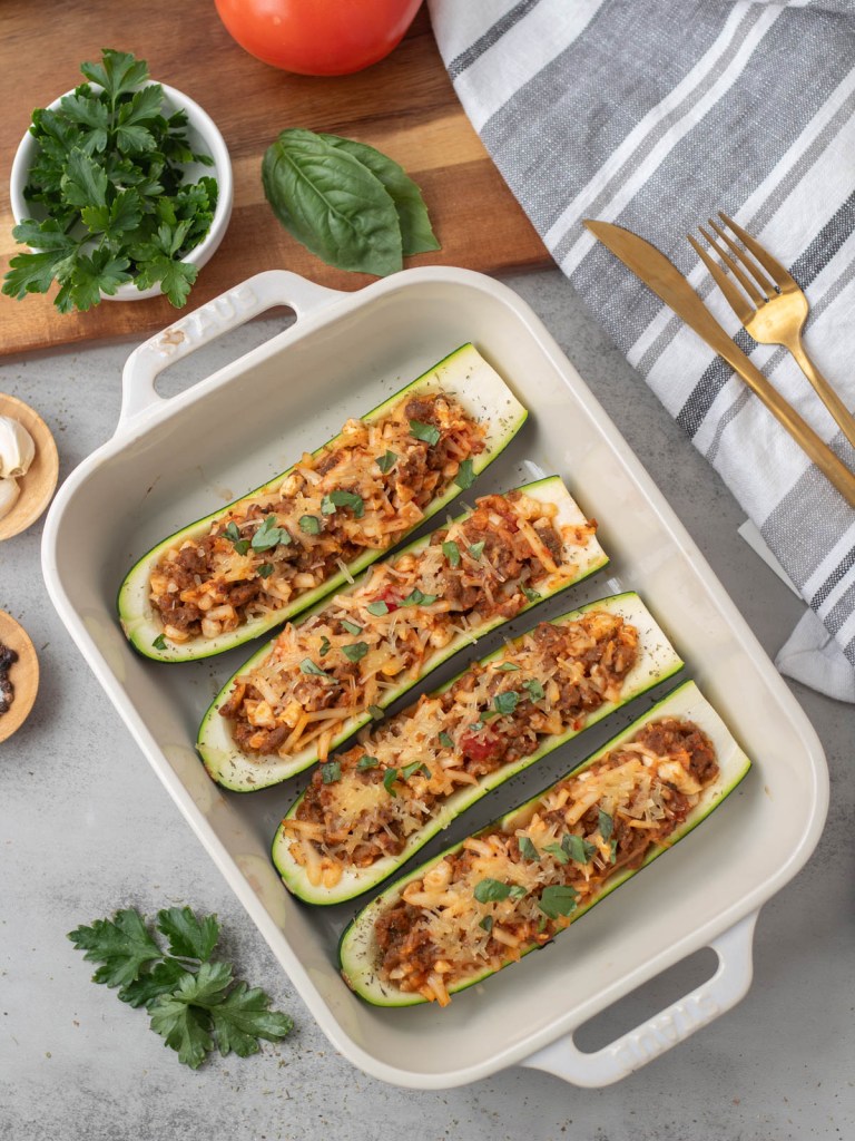 top view 4 stuffed zucchini in baking dish