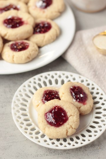 vegan raspberry thumbprint cookies on small lace plate