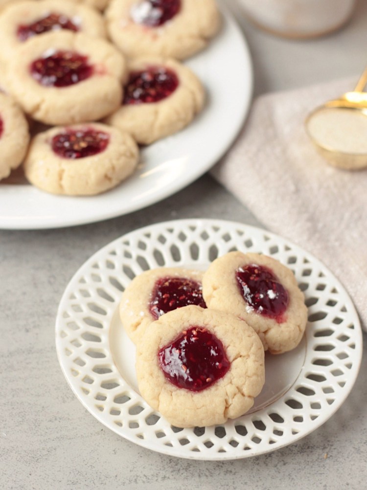 vegan raspberry thumbprint cookies on small lace plate