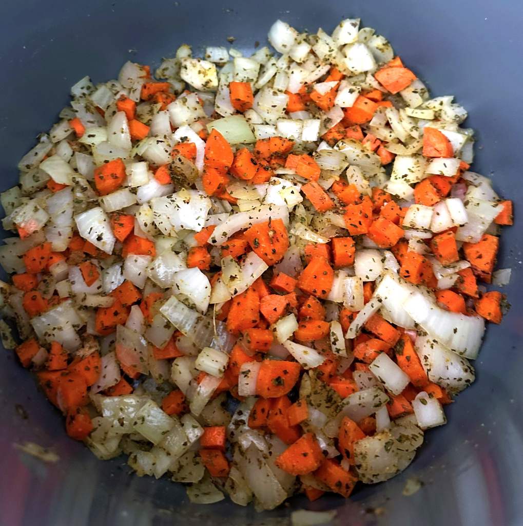 Chopped veggies and spices in a large stock pot