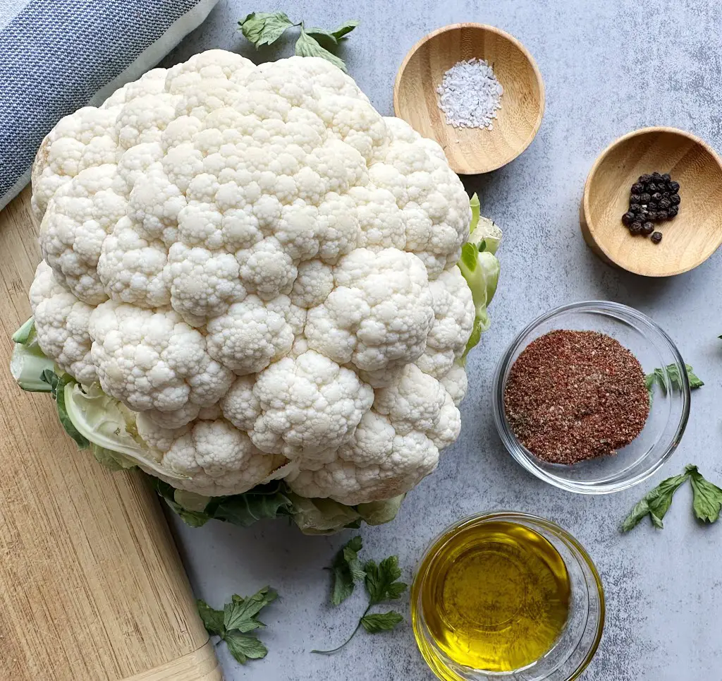 Ingredients for roasted cauliflower steaks on a grey background