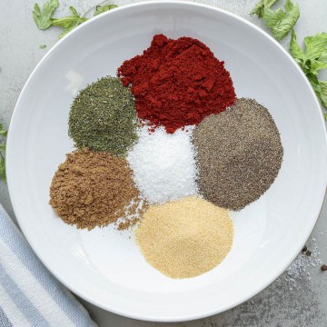 all spices for montreal steak seasoning separated in a white bowl