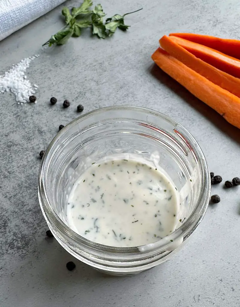Small cup of homemade vegan ranch dressing with carrots