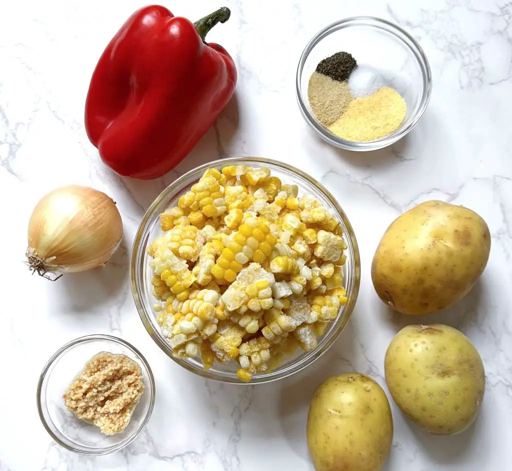 ingredients to make vegan corn chowder on a marble background