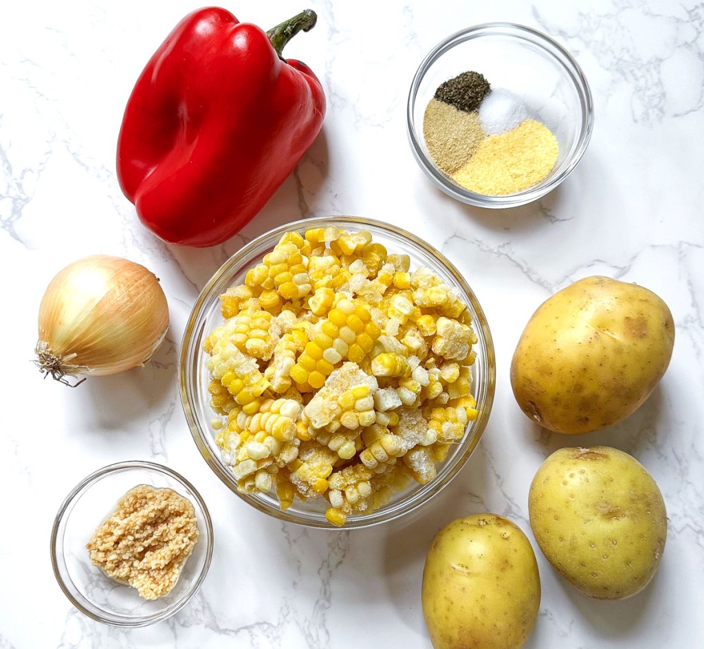 ingredients to make vegan corn chowder on a marble background