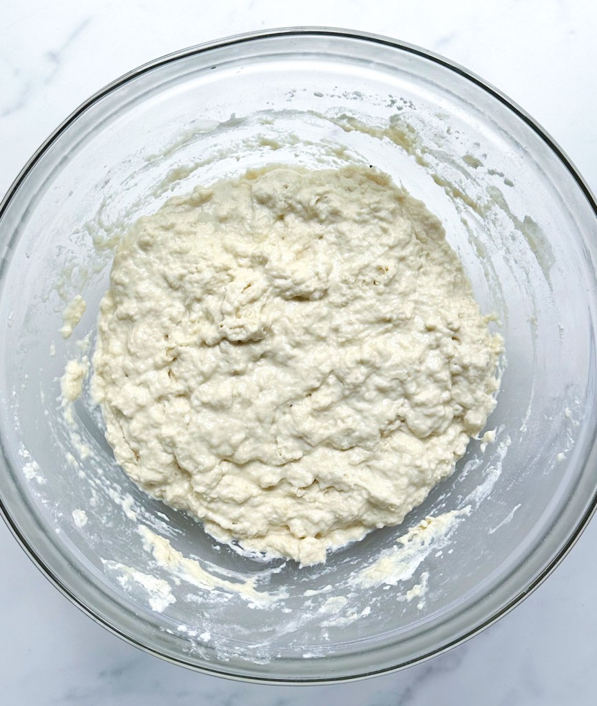 easy vegan focaccia dough after first mix in glass bowl