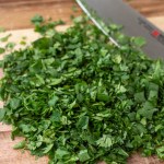 chopped fresh cilantro on a wood cutting board