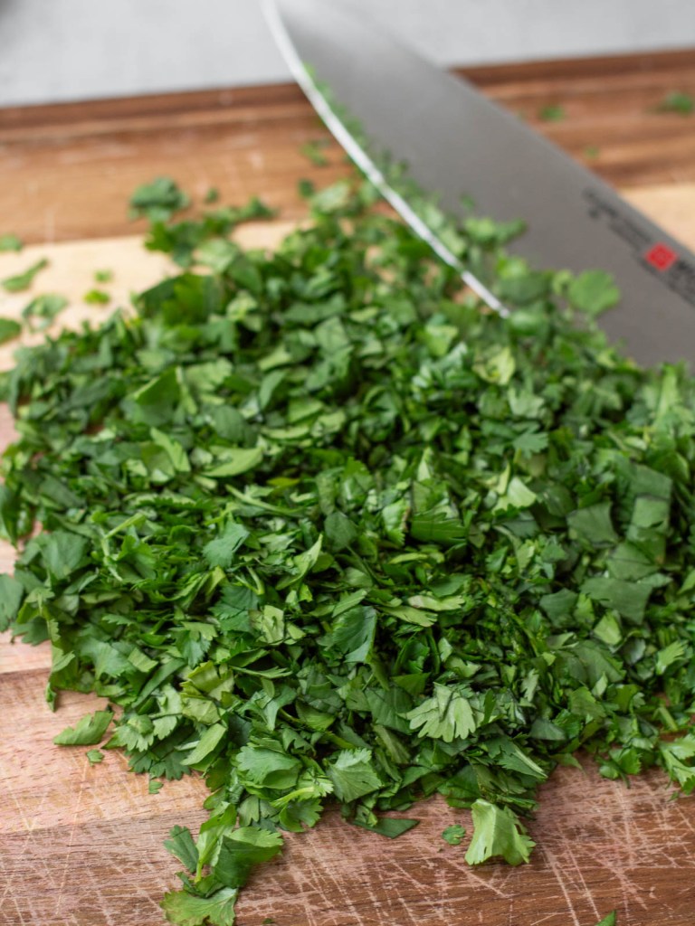 chopped fresh cilantro on a wood cutting board