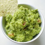 easy homemade guacamole with chip dipping from white bowl