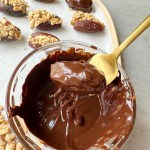 stuffed date being dipped in chocolate before freezing