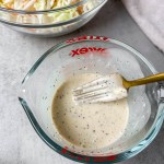 vegan coleslaw dressing being mixed with a fork