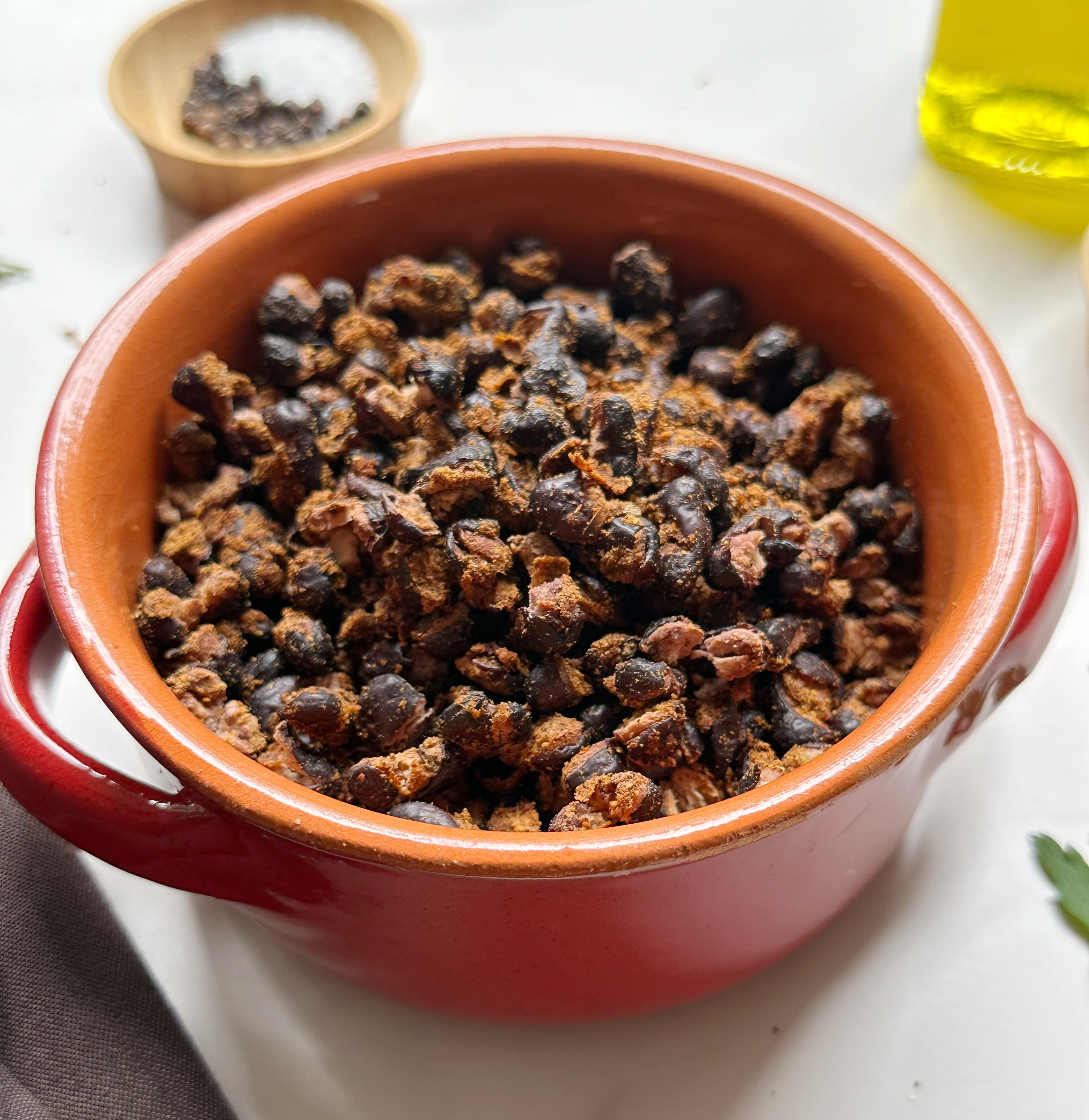 close up view of finished air fried black beans in an orange bowl