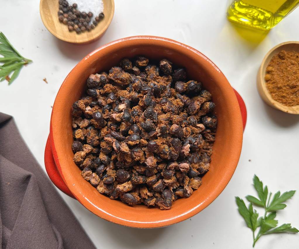 finished air fried black beans in an orange and red bowl