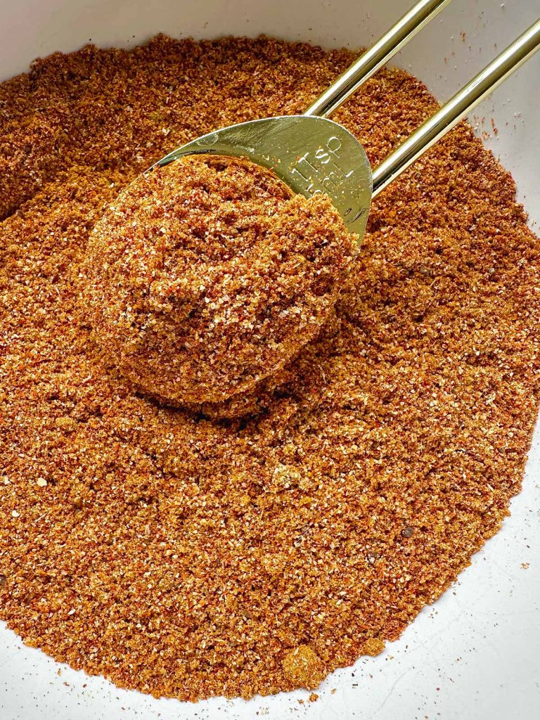 shawarma spices being mixed with measuring spoon in bowl