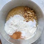 ingredients for vegan banana walnut cake in a large mixing bowl