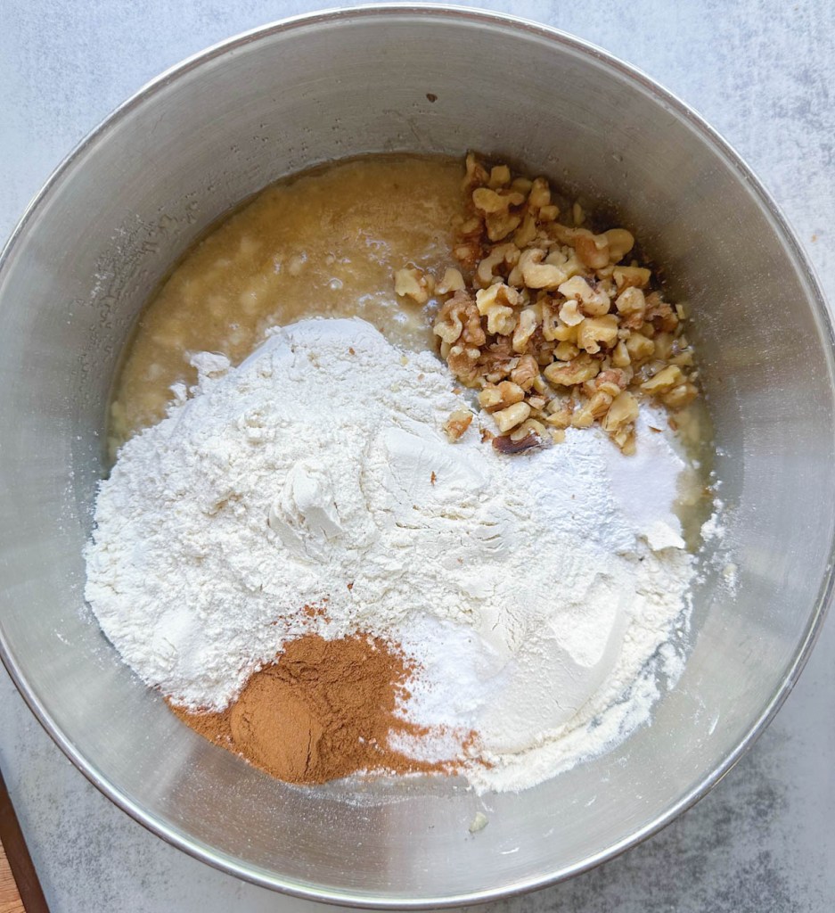 ingredients for vegan banana walnut cake in a large mixing bowl