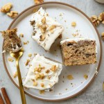 finished slices of vegan banana walnut cake with vegan frosting and crushed walnut topping