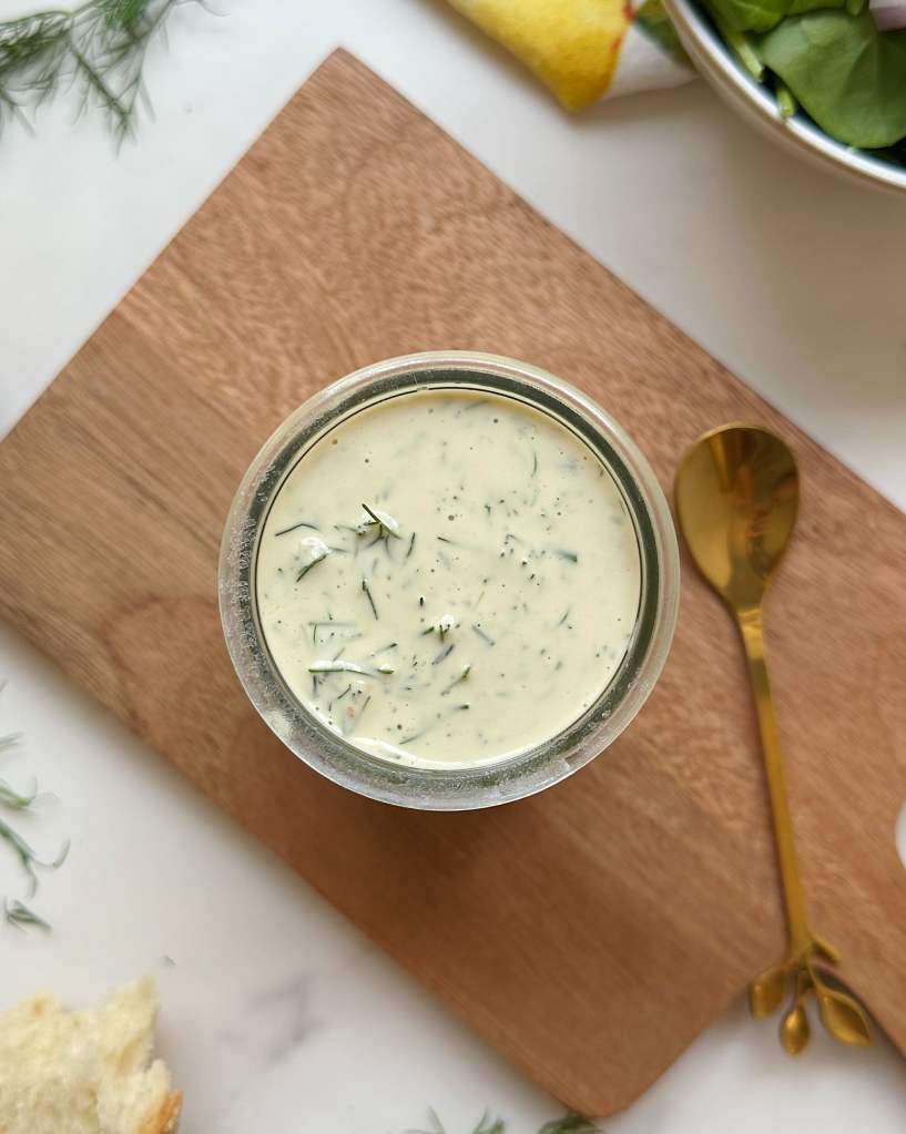 top view of vegan dill tahini dressing in a small glass jar 
