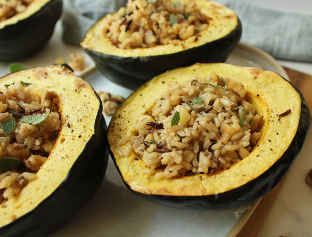 3 vegan stuffed acorn squash halves on a plate
