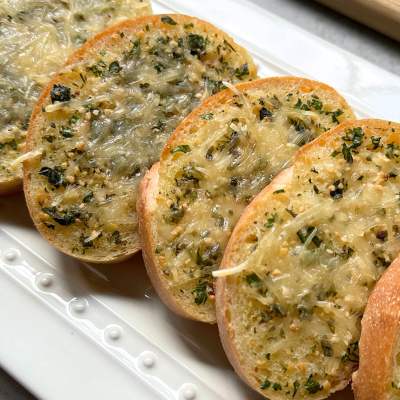 vegan cheesy garlic bread on a white plate