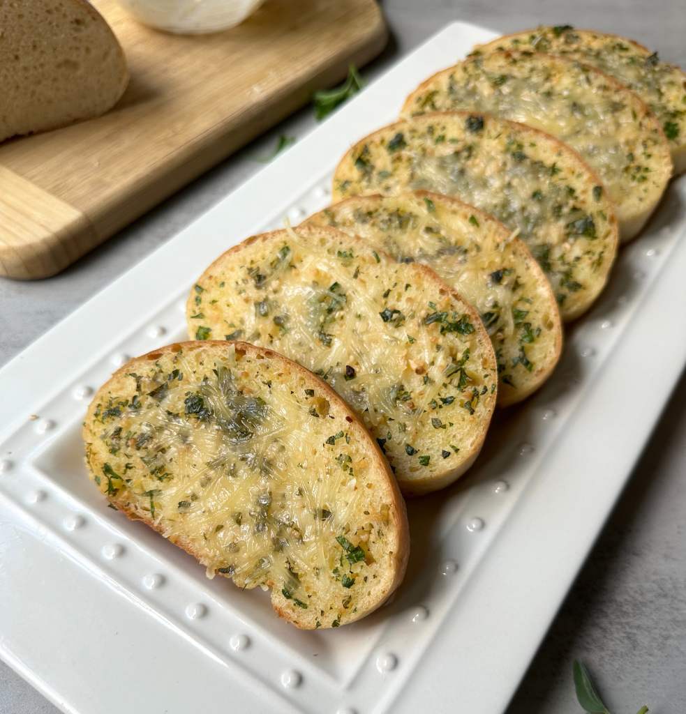 vegan cheesy garlic bread on a white serving plate