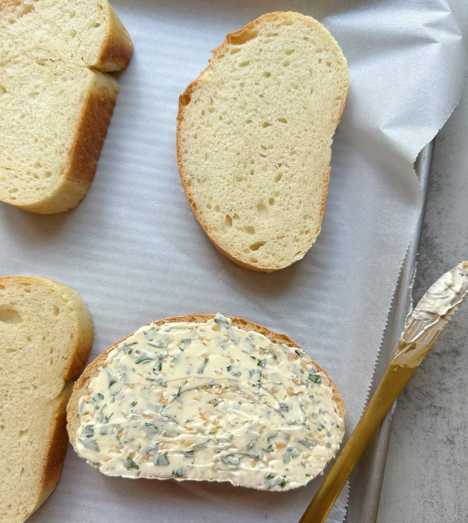 vegan italian bread with herb butter spread on it